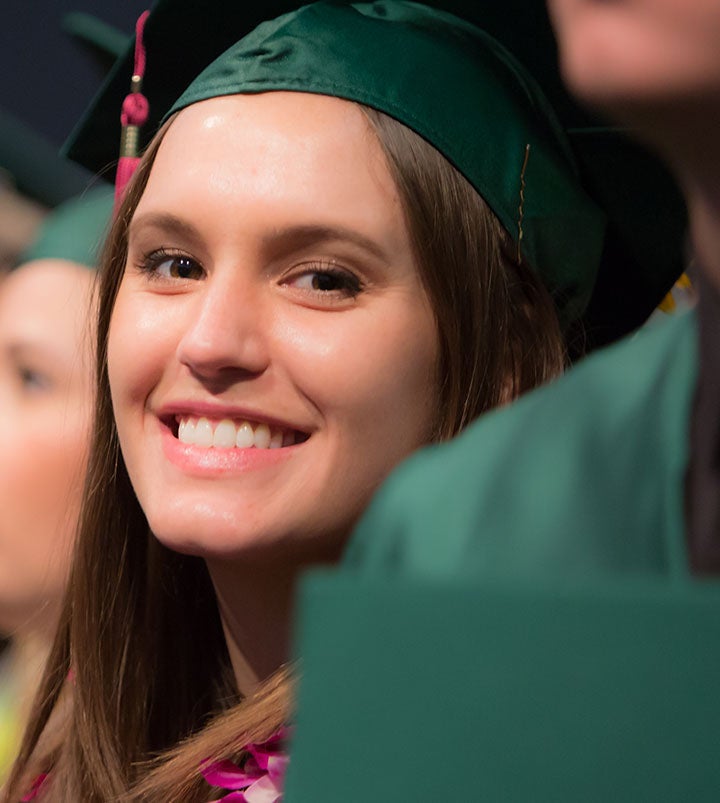 Female graduate in cap and gown at commencement Female graduate in cap and gown at commencement
