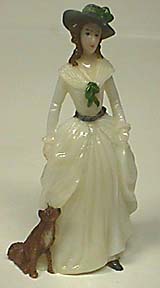 Lady of 1785 in while gown with green brimmed hat and her dog.