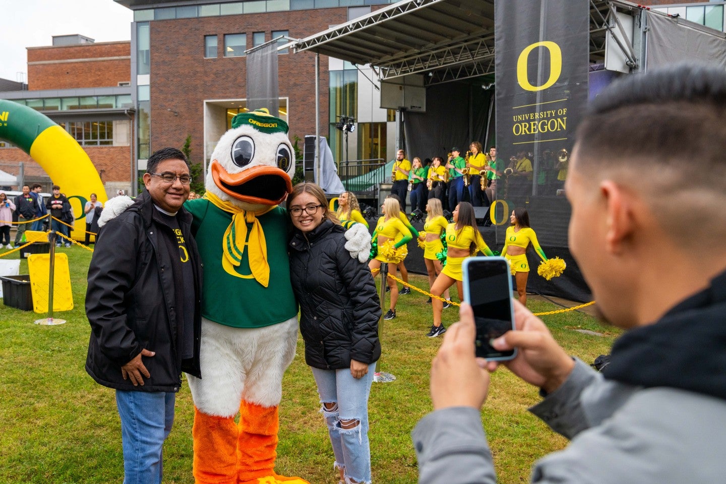 Two people posing for a photo with the Oregon Duck