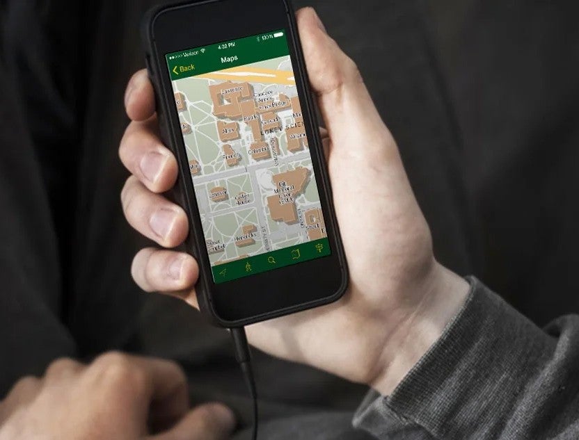 a hand hondling a phone with the the UO campus map on the screen