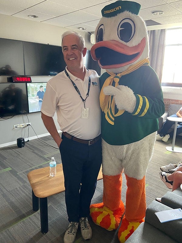 The Oregon Duck posing for a photo with Francois McGillicuddy, president of the Big Ten Network