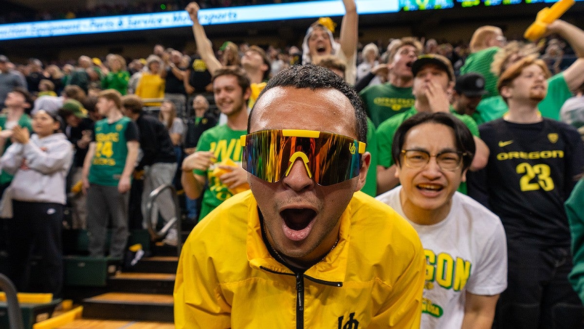 A Duck fan cheering into the camera in front of a crowd of fans