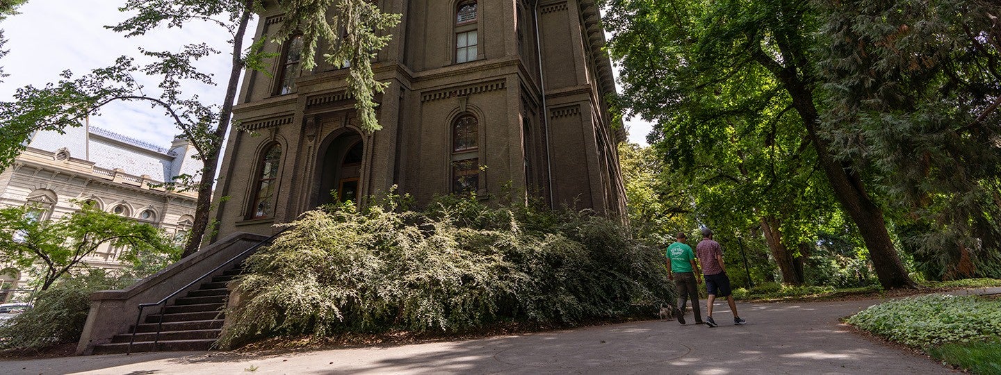 two students walking past Univesity Hall